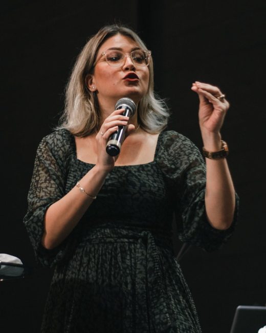 Speaker presenting on stage with a microphone